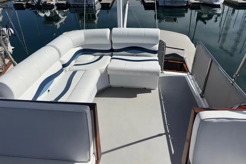 Slide: The Image of 1966 Grand Banks 32 Sedan with white seating on deck, docked at marina. - 32