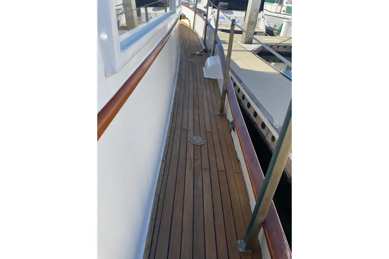 Slide: The Image of 1966 Grand Banks 32 Sedan yacht with teak deck and railing, docked at marina. - 36