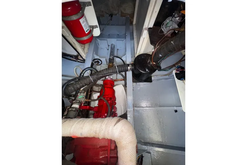Slide: The Image of Engine room of a 1966 Grand Banks 32 Sedan with visible fire extinguisher and piping. - 39