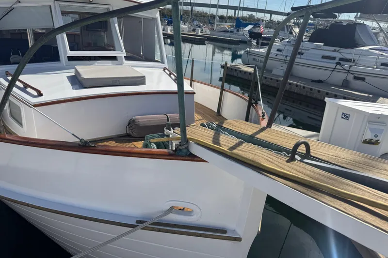 Slide: The Image of 1966 Grand Banks 32 Sedan docked at marina, showcasing classic wooden deck and cabin. - 4