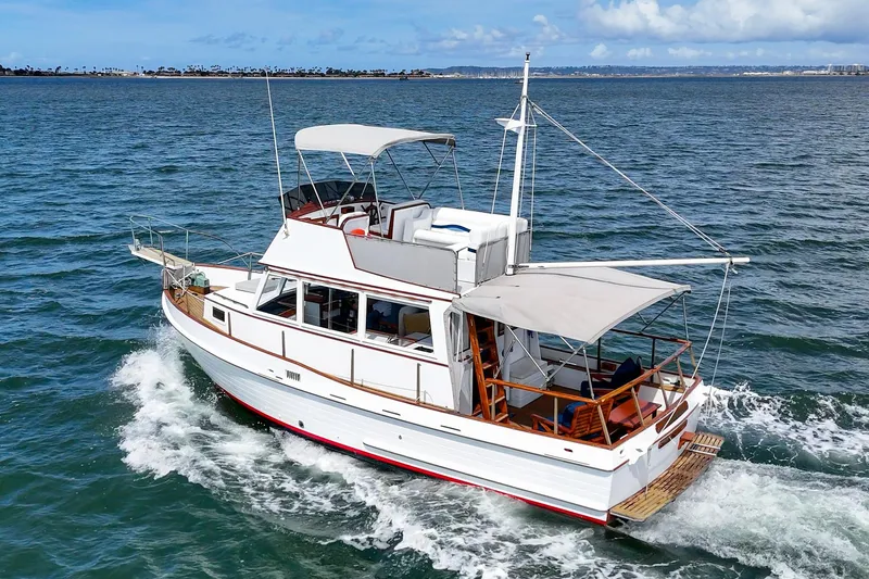 Slide: The Image of 1966 Grand Banks 32 Sedan cruising on open water under a clear sky. - 44