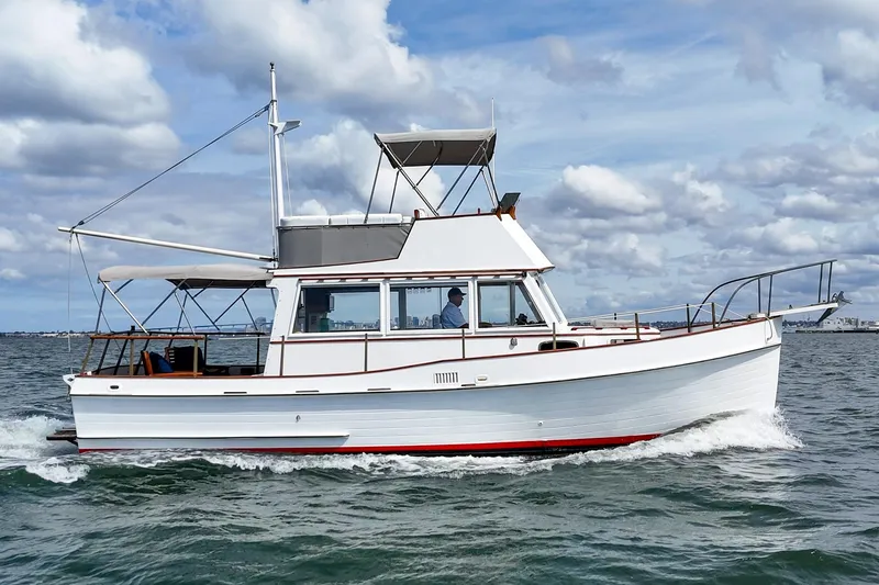 Slide: The Image of 1966 Grand Banks 32 Sedan cruising on open water under a cloudy sky. - 45