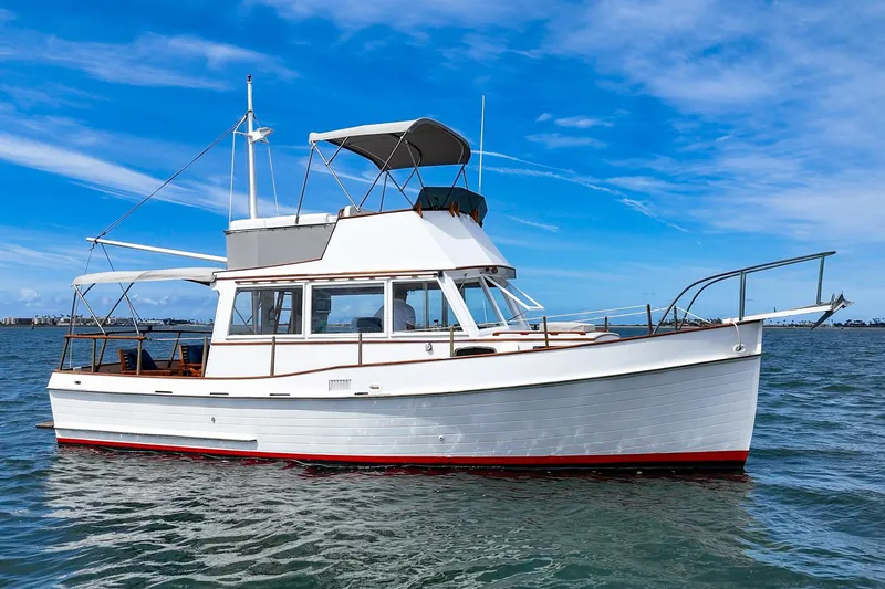 Slide: The Image of 1966 Grand Banks 32 Sedan boat on calm water under a clear blue sky. - 46