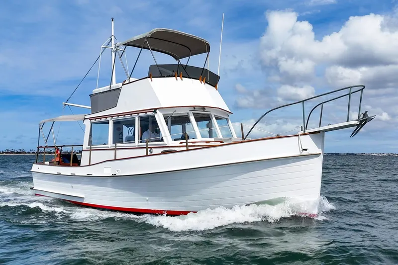 Slide: The Image of 1966 Grand Banks 32 Sedan cruising on open water under a partly cloudy sky. - 47