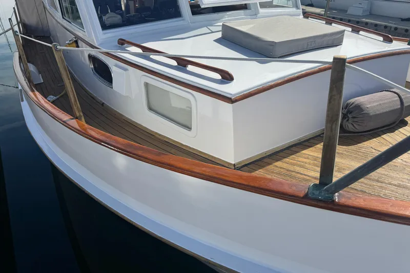 Slide: The Image of 1966 Grand Banks 32 Sedan boat with wooden deck and white exterior, docked at marina. - 5