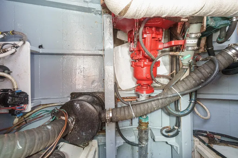 Slide: The Image of Engine room of a 1966 Grand Banks 32 Sedan with visible hoses and machinery. - 50