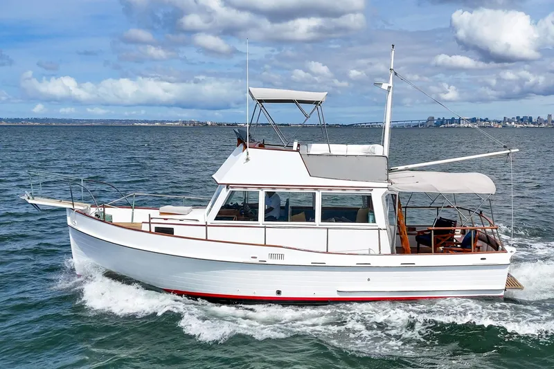 Slide: The Image of 1966 Grand Banks 32 Sedan cruising on open water under a partly cloudy sky. - 54
