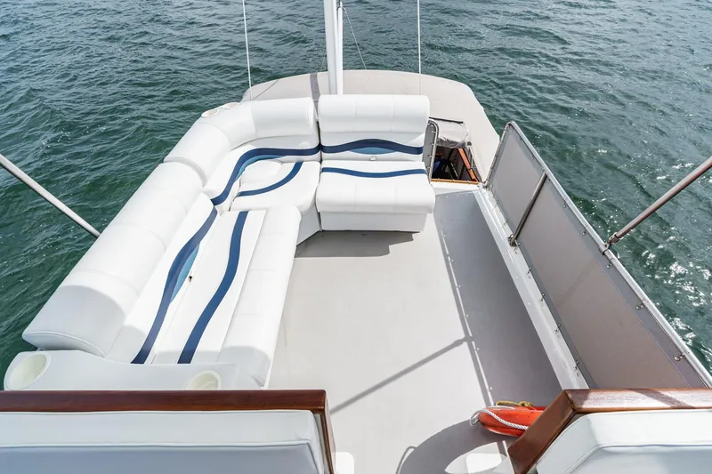 Slide: The Image of 1966 Grand Banks 32 Sedan boat deck with white seating and ocean view. - 57