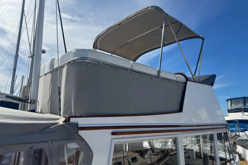 Slide: The Image of 1966 Grand Banks 32 Sedan boat with canopy, docked under clear blue sky. - 9