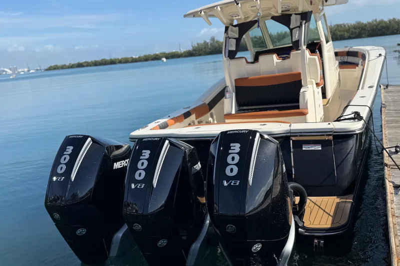 Slide: The Image of 2019 Scout 355 LXF boat with triple Mercury 300 V8 engines docked by the water. - 12