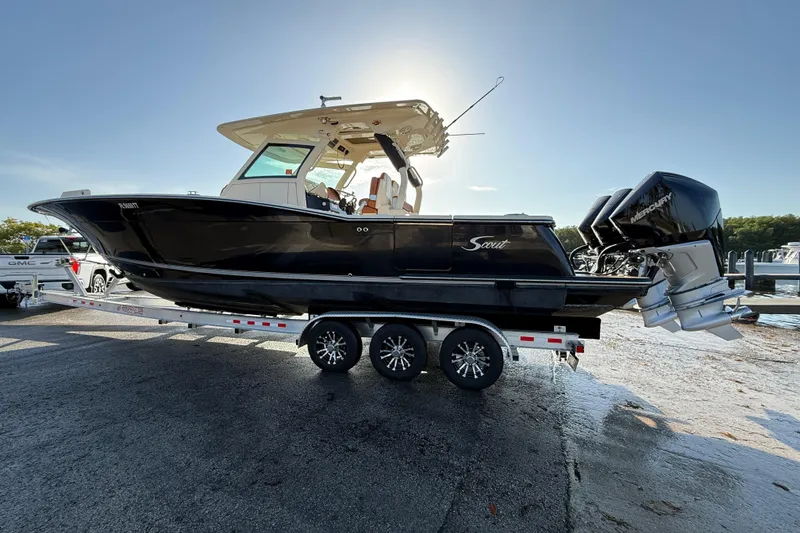 Slide: The Image of 2019 Scout 355 LXF boat on trailer with dual Mercury engines, parked outdoors. - 15