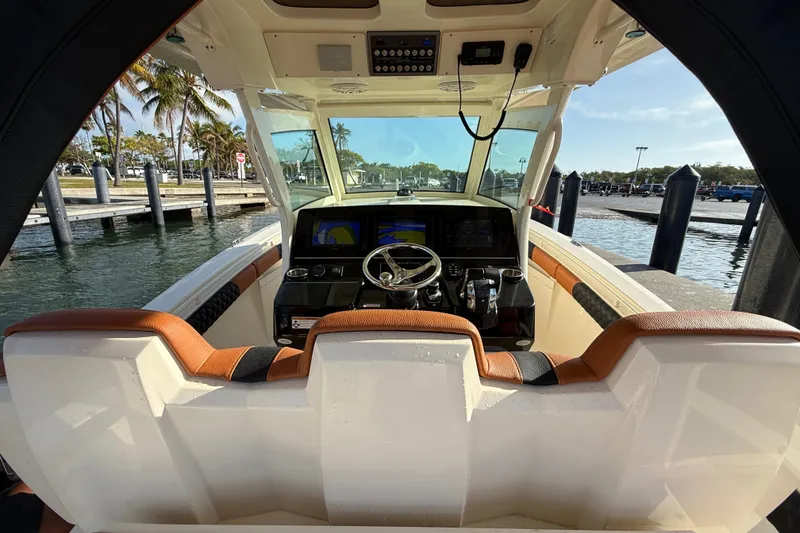 Slide: The Image of 2019 Scout 355 LXF boat cockpit with modern controls and waterfront view. - 16