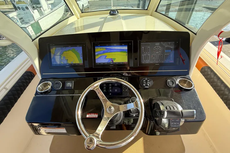 Slide: The Image of 2019 Scout 355 LXF boat dashboard with navigation screens and steering wheel. - 17