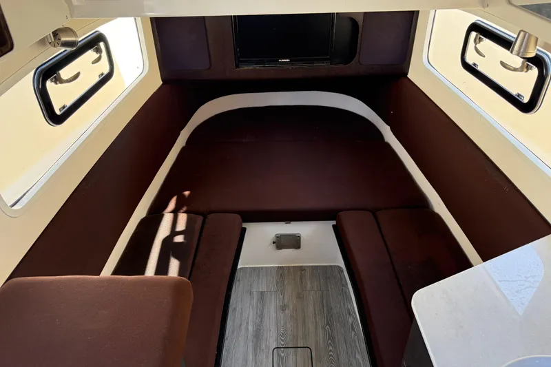 Slide: The Image of 2019 Scout 355 LXF cabin interior with brown seating and windows. - 33