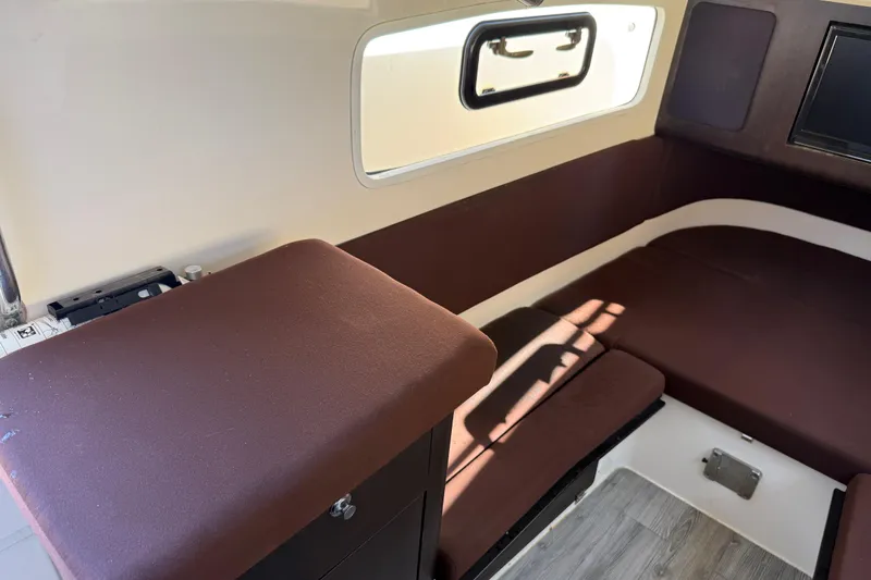 Slide: The Image of 2019 Scout 355 LXF cabin interior with brown seating and window. - 34