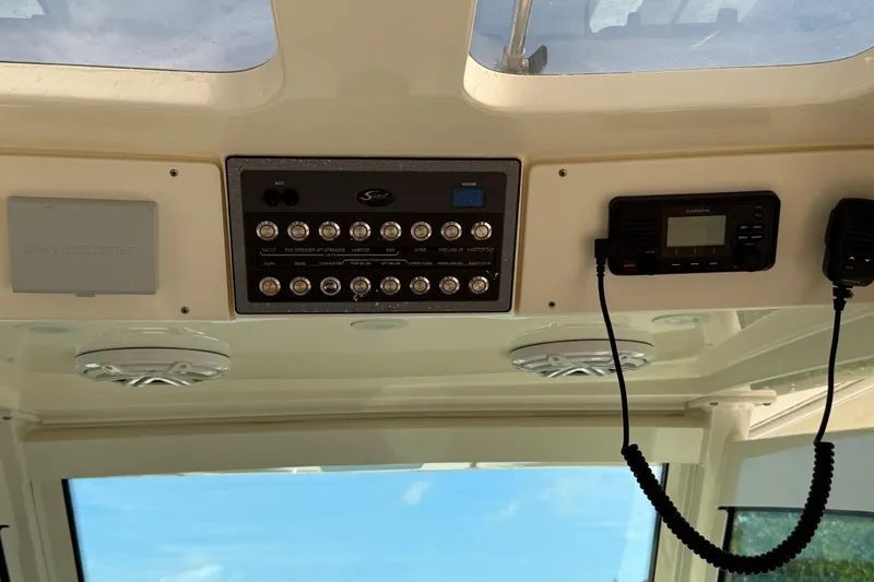Slide: The Image of 2019 Scout 355 LXF boat dashboard with control panel and communication devices. - 37