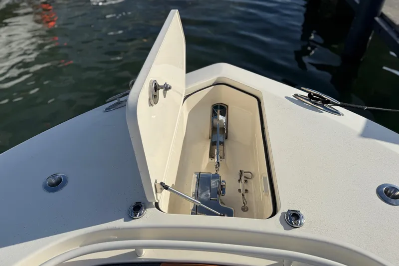 Slide: The Image of 2019 Scout 355 LXF boat anchor compartment open, docked on water. - 40