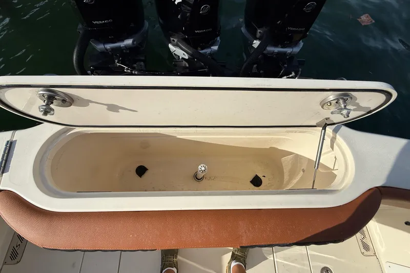 Slide: The Image of Open storage compartment on a 2019 Scout 355 LXF boat, with visible engines. - 48