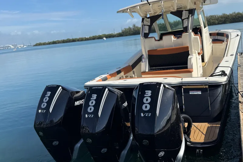 Slide: The Image of 2019 Scout 355 LXF boat with triple Mercury 300 V8 engines docked by the water. - 57