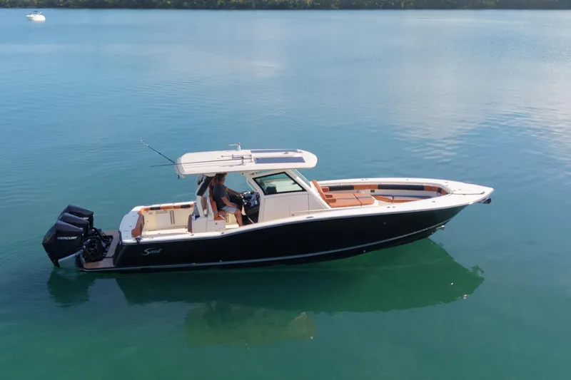 Slide: The Image of 2019 Scout 355 LXF boat on calm water, side view. - 7
