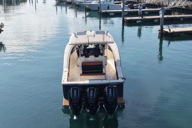 Slide: The Image of 2019 Scout 355 LXF boat with triple engines docked in a marina. - 9