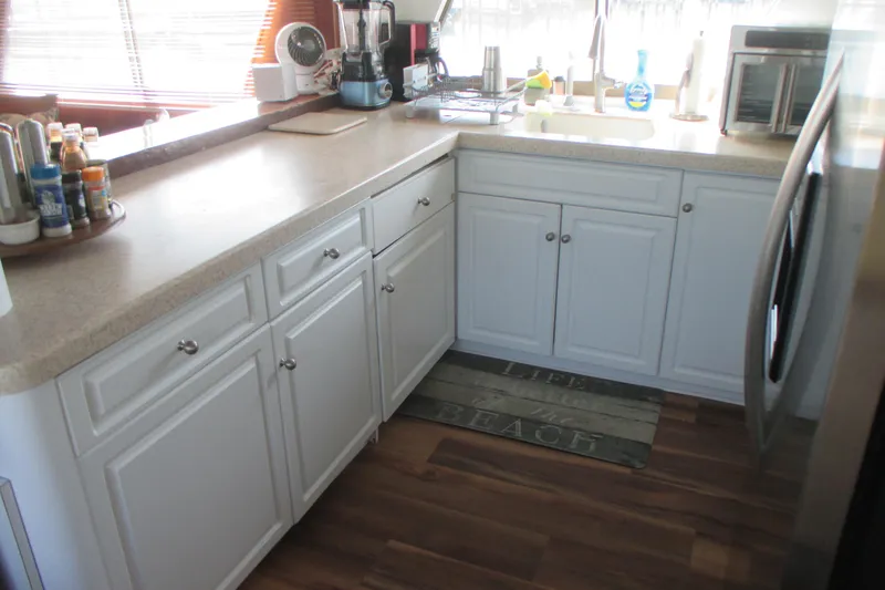 Slide: The Image of Kitchen interior of 1981 Hatteras 61 Motor Yacht with white cabinets and wooden floor. - 17