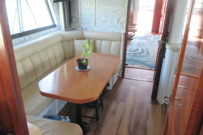 Slide: The Image of Interior of 1981 Hatteras 61 Motor Yacht with dining area and potted plant. - 19