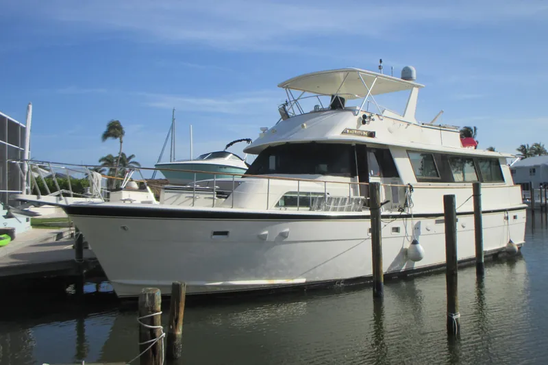 Slide: The Image of 1981 Hatteras 61 Motor Yacht docked in a marina under clear blue skies. - 2