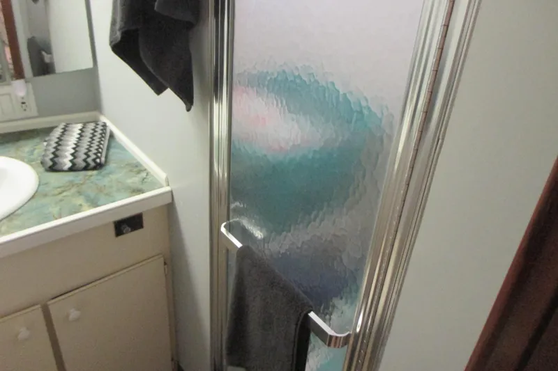 Slide: The Image of 1981 Hatteras 61 Motor Yacht deck with cushioned seating and wooden table. - 28