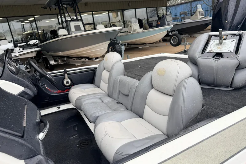 Slide: The Image of 2006 Skeeter 20i boat interior with gray seating, displayed at a dealership. - 7