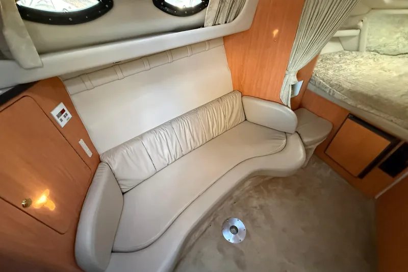 Slide: The Image of 2000 Regal Commodore 2760 cabin interior with beige seating and wood accents. - 11
