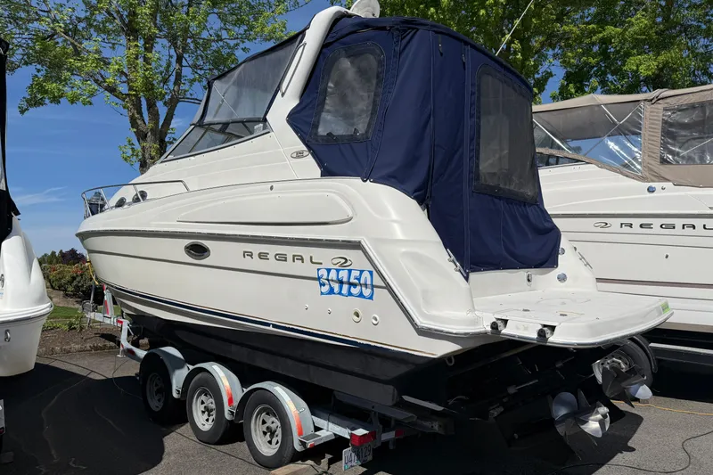 Slide: The Image of 2000 Regal Commodore 2760 boat on trailer, white with blue canopy, parked outdoors. - 22