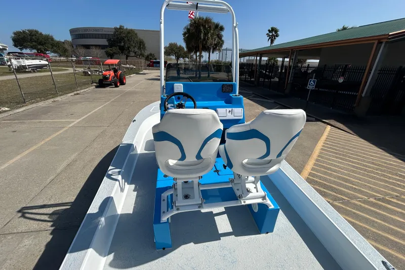 Slide: The Image of 2026 Gulf Coast Saber Cat boat with dual seats and steering console in a sunny outdoor setting. - 10