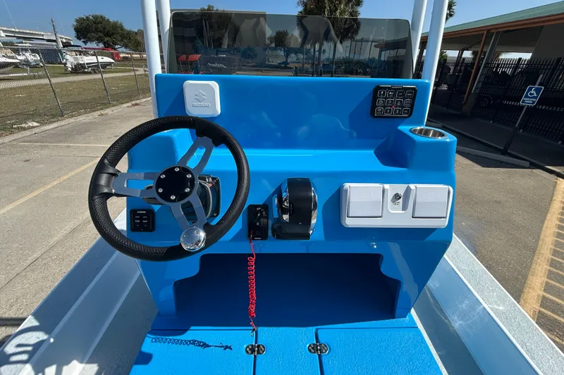 Slide: The Image of 2026 Gulf Coast Saber Cat boat console with steering wheel and control panel. - 11