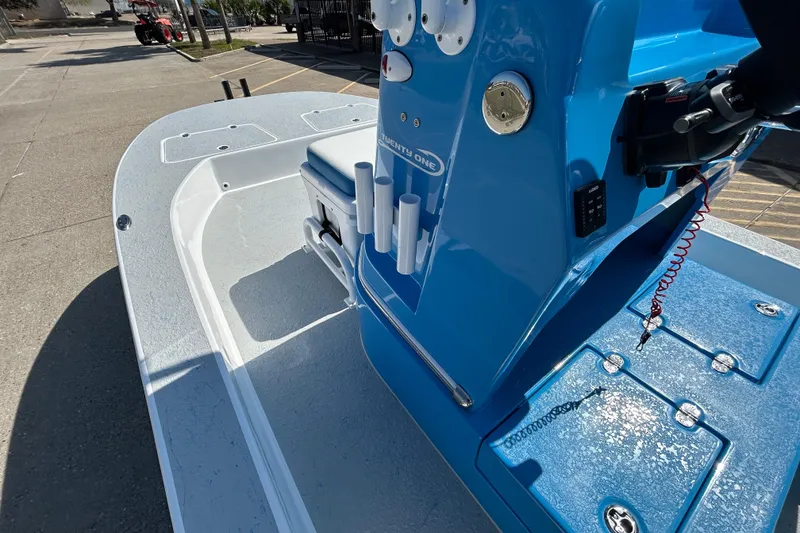 Slide: The Image of 2026 Gulf Coast Saber Cat boat with blue console and rod holders, docked outdoors. - 13
