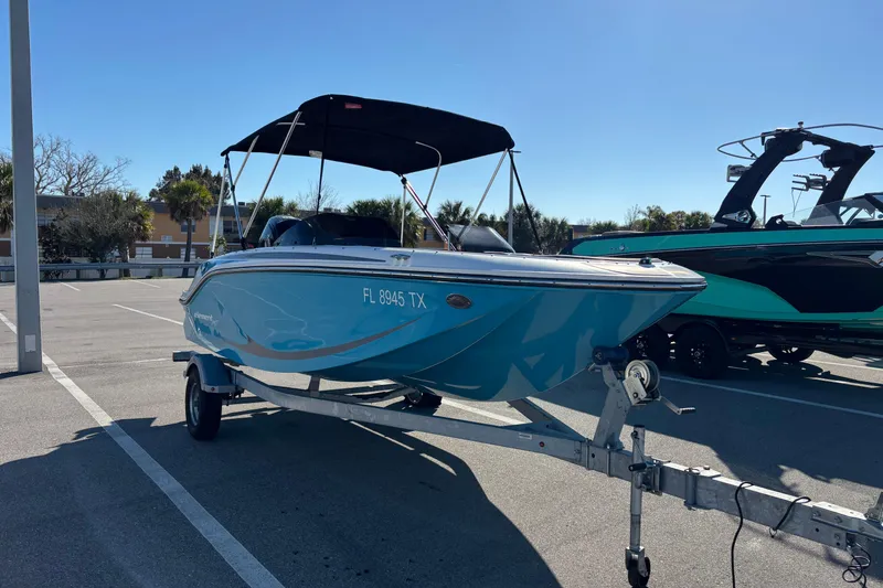 Slide: The Image of 2023 Bayliner Element M17 boat on trailer in parking lot, sunny day. - 2