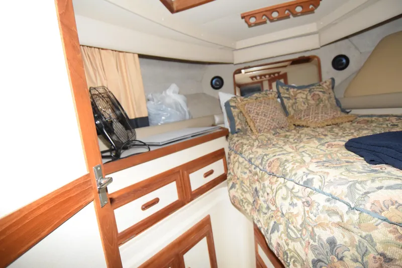 Slide: The Image of Cozy cabin interior of 1989 Carver 3297 Mariner with floral bedding and wood accents. - 5
