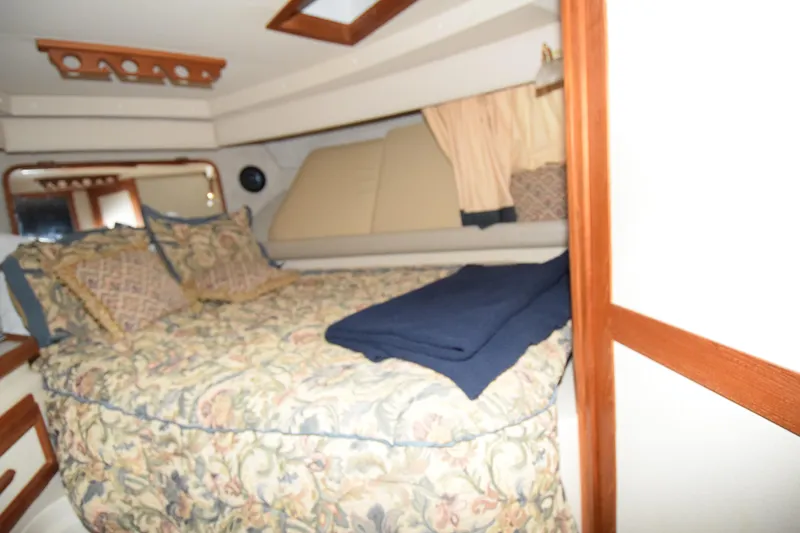 Slide: The Image of Interior cabin of 1989 Carver 3297 Mariner with floral bedding and wood accents. - 9