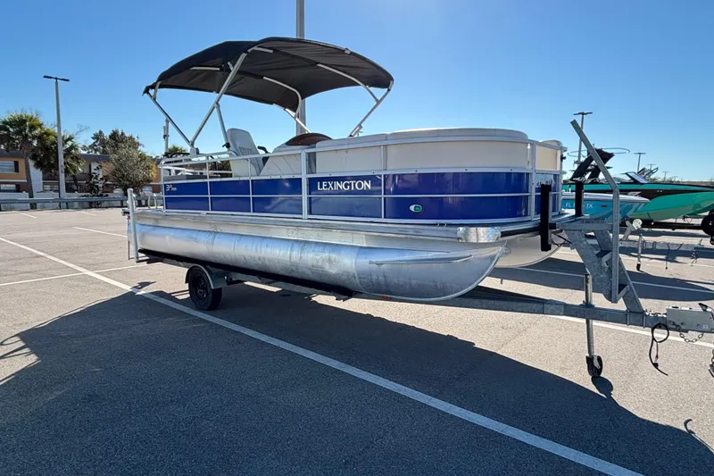 The Image of 2023 Lexington 321 Fish pontoon boat on trailer in sunny parking lot. - 0