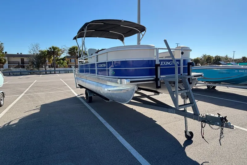 Slide: The Image of 2023 Lexington 321 Fish pontoon boat on trailer in parking lot. - 5