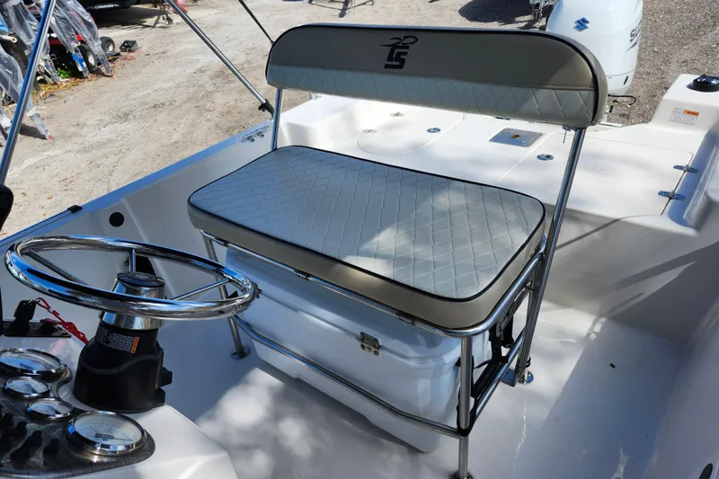 Slide: The Image of 2022 Carolina Skiff 178 JLS boat interior with steering wheel and cushioned seating. - 20