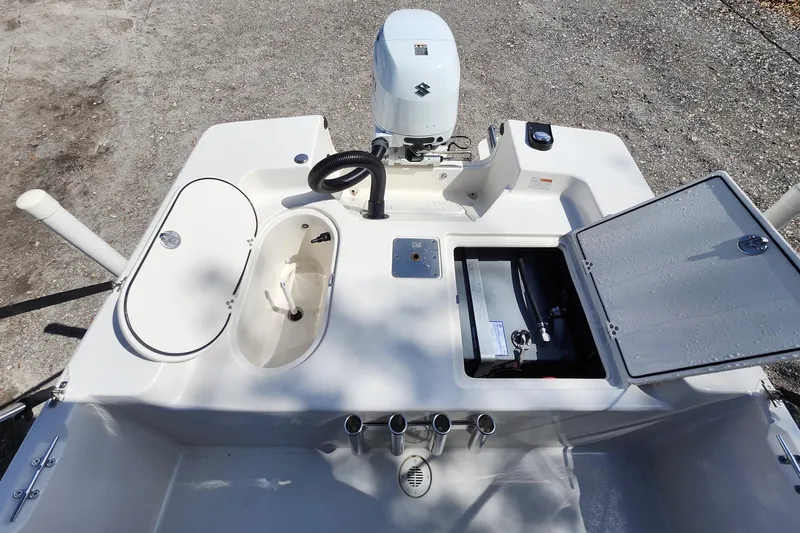 Slide: The Image of 2022 Carolina Skiff 178 JLS boat interior with open storage compartments and motor. - 25
