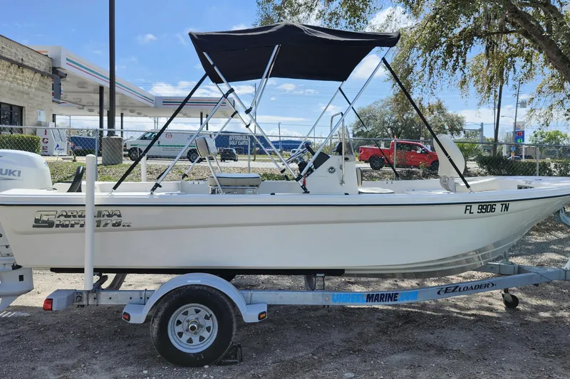 Slide: The Image of 2022 Carolina Skiff 178 JLS boat on trailer with canopy, parked outdoors. - 7