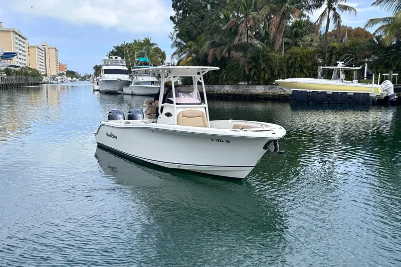 Slide: The Image of 2020 NauticStar 25 XS boat cruising in a scenic canal with palm trees. - 21
