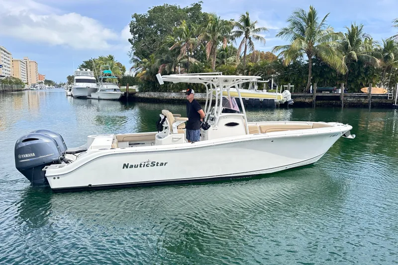 Slide: The Image of 2020 NauticStar 25 XS boat cruising on a scenic waterway with palm trees. - 27