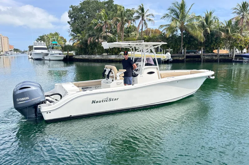 Slide: The Image of 2020 NauticStar 25 XS boat cruising on a scenic waterway with palm trees. - 28