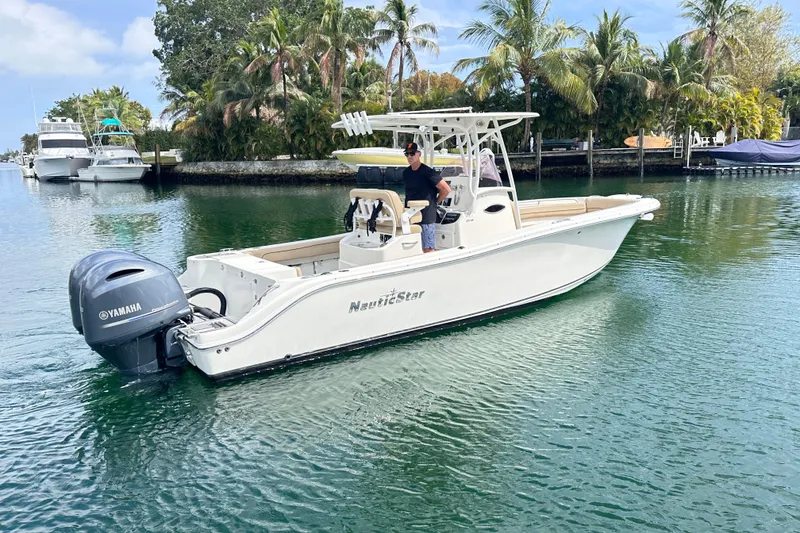 Slide: The Image of 2020 NauticStar 25 XS boat cruising on a calm, tropical waterway. - 29