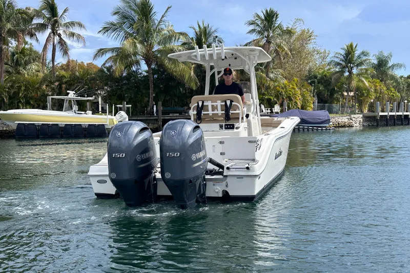 Slide: The Image of 2020 NauticStar 25 XS boat with dual Yamaha engines on a tropical waterway. - 33