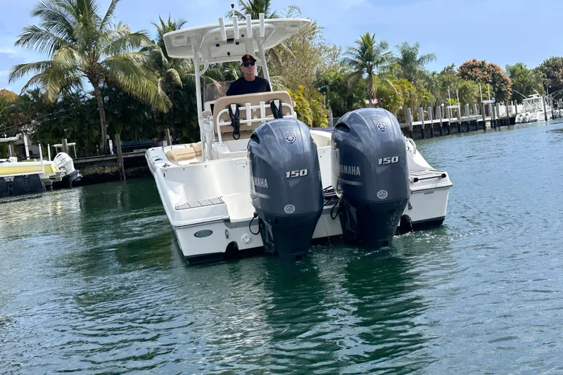 Slide: The Image of 2020 NauticStar 25 XS boat with dual Yamaha 150 engines on a tropical waterway. - 37