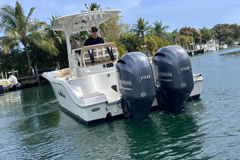 Slide: The Image of 2020 NauticStar 25 XS boat with twin Yamaha 150 engines on a tropical waterway. - 39